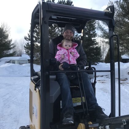 Randalls Equipment owner showing his daughter Annika her new toy